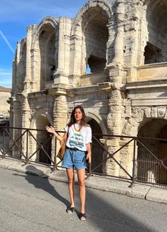 a woman standing in front of an old building