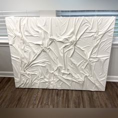 a large white sculpture sitting on top of a hard wood floor