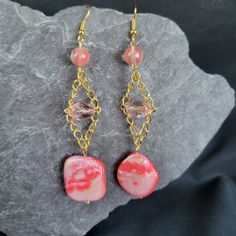 Add a playful pop of color to your accessory collection with our Pink Shell Trapeze Earrings! Made with a pink shell bead on a trapeze chain, these earrings also feature clear pink and round pink beads for a fun and unique look. Perfect for any occasion! Pink Beads, Shell Beads, Style Earrings, Gemstone Earrings, Jewelry Earrings Dangle, Etsy Earrings, Color Pop, Dangle Drop Earrings, Shells