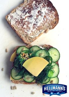 two slices of bread with cucumbers and cheese on them sitting next to each other