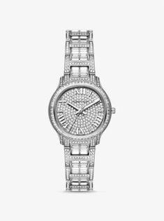 As a opulent accent to everyday looks or a precious gift to a loved one, the limited-edition Sage watch delivers a maximum dose of sparkle in a chic, minimalist package. Crafted from stainless steel, this silver-tone timepiece features a glittering pavé-encrusted bracelet strap and dial for statement-making appeal. A three-hand quartz movement and Roman numeral time stops add a classic finish. Its slender casebody reverses to reveal Michael’s signature and a unique identification number, while t Elegant Stainless Steel Diamond Watch With Diamond Accents, Elegant Stainless Steel Diamond Watch With Accents, Silver Watch With Timeless Design And Round Dial, Elegant Stainless Steel Watches With Diamond Accents, Modern White Gold Watches With Diamond Accents, Modern Anniversary Watches With Diamond Accents, Elegant Stainless Steel Diamond Watch With Metal Dial, Elegant Silver Diamond Watch With Subdials, Timeless Stainless Steel Diamond Watch With Polished Finish