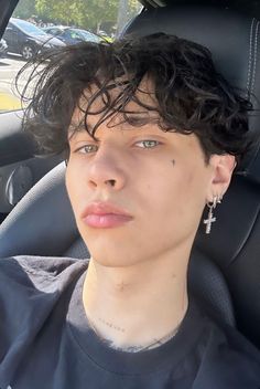 a young man sitting in the back seat of a car with his head turned to the side