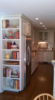 a kitchen with white cabinets and wooden floors