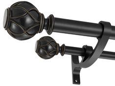 two black curtain rods with gold details on them