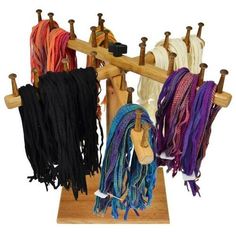 several different colored scarves are hanging on a wooden rack