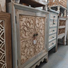 an old dresser with ornate carvings on the doors and drawer fronts is displayed in a store