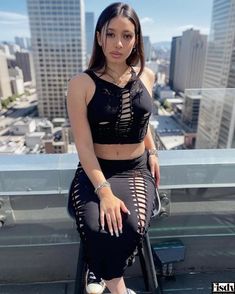 a young woman sitting on top of a building