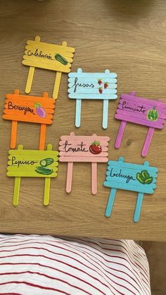 four wooden signs with names on them sitting on top of a table next to a bed