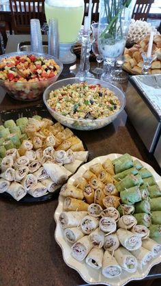 a table filled with different types of food on plates and serving trays next to each other