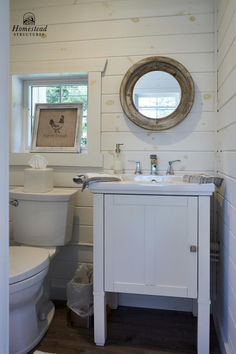 a bathroom with a sink, toilet and mirror in it's center piece is shown