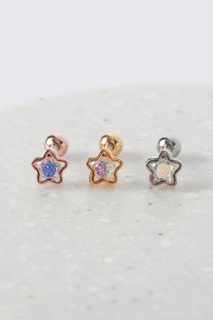 The 'AURORA STARBUST' earrings are a stunning pair of stud earrings that feature a starburst design with a sparkling cubic zirconia stone in the center. The stone is set in a hollowed-out star-shaped clasp and the design is reminiscent of a burst of light, just like the stunning aurora borealis. These earrings are small in size, making them perfect for everyday wear, but the sparkly design is sure to catch the eye of anyone who sees them. Please note that the clasp on these earrings is designed Celestial Star-shaped Sparkling Earrings, Sparkling Star-shaped Celestial Earrings, Celestial Star-shaped Piercings For Gifts, Celestial Star-shaped Piercings As Gift, Celestial Star Piercings Gift, Rose Gold Star Charm Earrings, Rose Gold Star Earrings With Star Charm, Rose Gold Star-shaped Earrings With Star Charm, Star-shaped Cubic Zirconia Earrings With Star Charm