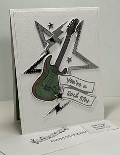 a white card with a guitar and stars on it, which says you're a rock star