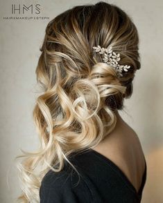 the back of a woman's head with wavy hair and flowers in her hair