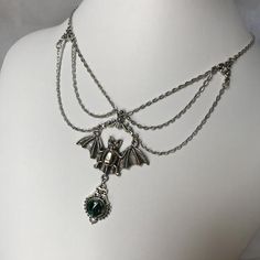 This gothic vampire inspired necklace is made with an antiqued silver plated bat. filigrees and findings, accented with sparkling glass crystals in EMERALD GREEN. Decorated portion is 6" wide and centerpiece is 2 7/8" tall in the center.Necklace is adjustable 15-18" with a lobster clasp and chain extender in the back. If you would like a different length or stone color, please send us a message. Gothic Nickel-free Necklace For Halloween, Gothic Nickel-free Necklaces For Halloween, Silver Vampire Style Necklace, Nickel-free Gothic Necklaces For Party, Silver Vampire Style Metal Jewelry, Silver Fantasy Costume Jewelry, Silver Steampunk Jewelry For Party, Silver Vampire Costume Jewelry, Silver Vampire Style Costume Jewelry