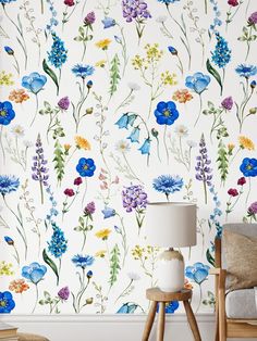 the wallpaper in this room is painted with blue, yellow and purple flowers on it