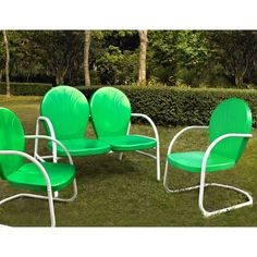 four green lawn chairs sitting in the grass