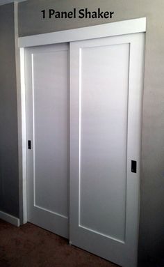 an empty room with two white doors and carpet