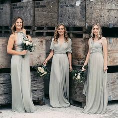 three bridesmaids standing in front of wooden crates