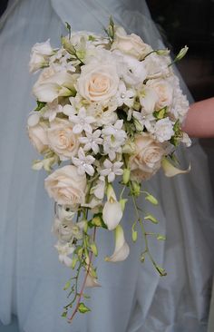 a bride holding a bouquet of white flowers