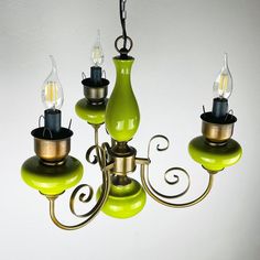 a green chandelier with five lights hanging from it's sides and two on each side