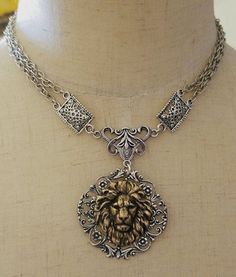 This lion choker necklace is designed and handcrafted by Viviana Jewelry Designs.  The pendant is the finest sterling silver plated brass vintage style filigree and bronze lion stamping that was made in the USA.  the chain and other jewelry findings are silver plated.  This is a stunning necklace that is certainly an eye catcher.  My lion necklaces continue to be very popular with my customers.   This is a choker necklace which typically is 14 inches long, however, everyone's necklace size is different.  Please specify what length that you want your choker necklace to be when ordering.   Will ship priority, but if you want priority or, please contact me directly prior to ordering.   Thank you for shopping Viviana Jewelry Designs.  Have a blessed and wonderful day.   Best, Vivian Luxury Silver Warrior Style Jewelry, Luxury Ceremonial Necklaces With Historical Design, Luxury Historical Ceremonial Necklaces, Luxury Classic Jewelry With Coat Of Arms, Luxury Medieval Jewelry Gift, Luxury Ornate Hand-set Necklace, Luxury Medieval Silver Jewelry, Luxury Carved Necklaces For Wedding, Luxury Ornate Metal Necklaces