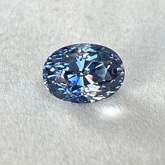 a blue diamond sitting on top of a white surface