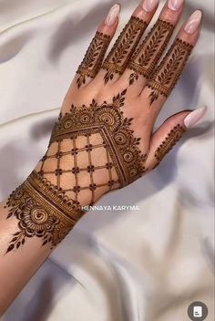 a woman's hand with henna tattoos on it