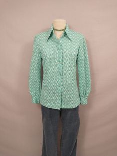 "Fun authentic vintage seventies dacron polyester blouse. Washable (washed, hang dry) . Full button down with classic shirt collar, long length. Double button on each wrist cuff. Size marked 14, vintage sizing is different - please go by measurements, it is on a 6 dress form and there is room.  Long sleeves. Condition very good, no stains or damage. Length 26\" Shoulders 17\" Bust 37\" Sleeve 23.5\" wt 7oz" Retro Collared Button Blouse, Retro Collared Blouse With Buttons, Retro Button-up Fitted Blouse, Retro Fitted Button-up Blouse, Retro Spring Button-up Shirt, Vintage Button-up Blouse For Fall, Retro Green Button-up Shirt, Retro Collared Blouse For Work, Retro Long Sleeve Blouse For Vintage Fashion