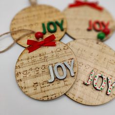 four wooden ornaments with the words joy, joy and joy written on each ornament