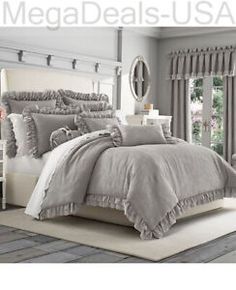 the comforter is made up with ruffled trims and grey bedding,