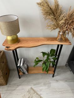 a wooden shelf with two plants on it and a lamp next to it in a room