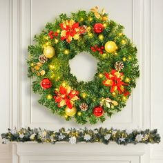 a christmas wreath on the wall next to a fire place with ornaments and lights around it