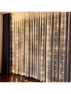 curtains with lights on them are hanging in front of a curtain that has sheer drapes