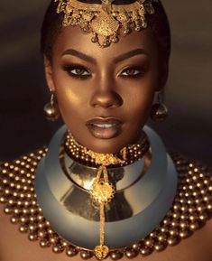 an african woman wearing gold jewelry and pearls