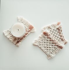 two knitted napkins and a candle on a white surface