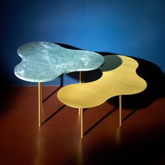 three tables sitting on top of each other in front of a blue wall and floor