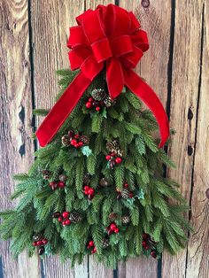 a christmas tree made out of pine cones and red bows