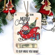 a christmas ornament hanging from a tree with money in it's mouth