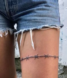 a woman's leg with barbed wire on it and the bottom part of her thigh