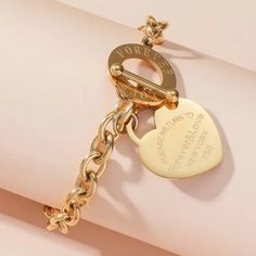 18k Gold Plated Titanium Steel Toghle Lock Style Bracelet "Return To Sender... " 9.06 Inches Gold Stainless Steel Heart Bracelet For Anniversary, Anniversary Gold Metal Bracelet Tarnish Resistant, Anniversary Gold Metal Bracelet, Gold Metal Charm Bracelet With Toggle Clasp, Gold-plated Bracelet With Toggle Clasp As Gift, Gold Metal Chain Bracelet For Valentine's Day, Gold Metal Heart Bracelet For Anniversary, Valentine's Day Gift Bracelet With Toggle Clasp, Gold Metal Charm Bracelet For Anniversary