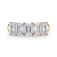 an emerald cut diamond ring with three baguets on each side and two diamonds in the middle