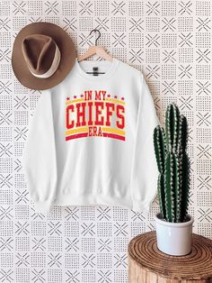 In My Chiefs Era Sweatshirt, Women's Chiefs T-Shirt, Team Mascot Shirt, School Spirit Sweater, Chiefs Jersey Shirt  !!How To Order 1-) Please, Check and Review all Photos. 2-) Select Your Product Type and Color. 3-) Select Your Product Size. 4-) Click ADD TO CART and You can go back to add more product color and text color or You can complete the checkout process. 5-) After You added your note, Please Click "Proceed to Check Out" ❤ Washing Instructions: For best results, wash inside out and lay flat to dry. Wash with like colors. Crew Neck Tops With Lettering For Fan Gear, Crew Neck Tops With Lettering For Fans, Letter Print Crew Top For Fan Merchandise, White Fan Gear Top With Lettering, Chiefs Jersey, Mascot Shirt, Team Mascots, School Spirit, Jersey Shirt