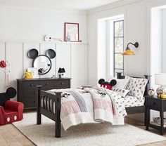 a bedroom with mickey mouse bedding and furniture