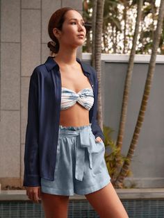 Stay cool and stylish this spring in our 100% silk Charlotte shorts. Featuring a comfy, adjustable waistband and a playful ruffle trim, these pull-on shorts offer effortless elegance. Soft elastic and darling patch pockets add a touch of sophistication, while the subtle sheen lets them transition from poolside lounging (pair with a bikini!) to breezy nights (think cozy sweater and sandals). The perfect versatile piece for brunches, picnics, garden parties, and beyond! 100% Washed Silk Taffeta Measurements: Inseam 2.25”, Inseam to Waist 12.5” Chic High-waisted Pajama Shorts For Beach, Chic Pajama Shorts For Vacation, Chic High-waisted Pajama Shorts With Elastic Waistband, Blue Shorts For Summer Daywear, Blue Summer Shorts With Ruffles, Chic Pajama Shorts, Blue Shorts For Spring Daywear, Blue Ruffled Shorts For Summer, Trendy Blue Pajama Shorts For Spring