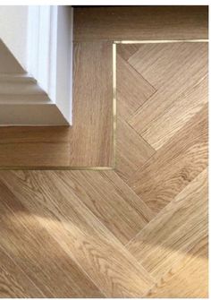 an image of wood flooring that looks like chevron herringbones with gold trim