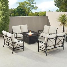 an outdoor fire pit with four chairs around it