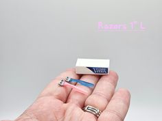 a person holding two toothbrushes in their palm with the word razors on it