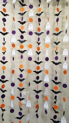 halloween decorations hanging on the wall with bats and pumpkins