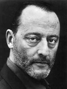 an old black and white photo of a man in a suit looking at the camera