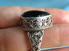 Featured is this lovely vintage BA Suarti sterling and black onyx ring. Beautiful  cannetille sterling work on the setting!  It is in very good used condition and measures a size 7.  The front portion measures approx. 7/8" tall at center.   No issues found. The ring is marked on the inside of band: 925 BA INDONESIA.   May want to give a gentle polishing, if desired.  The ring weighs 13.1 grams.  Nice gift for him or her. **All of my listings are vintage, which means they will naturally show some Antique Black Jewelry With Intricate Design, Antique Oval Onyx Jewelry, Black Filigree Ring Jewelry, Black Filigree Ring, Bohemian Cabochon Jewelry For Formal Occasions, Formal Bohemian Jewelry With Cabochon, Formal Bohemian Cabochon Jewelry, Ornate Black Sterling Silver Rings, Black Cabochon Jewelry For Wedding